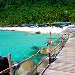 Show thumbnail preview	 Wooden walkway along a tropical beach with clear turquoise water, boats, and palm trees.